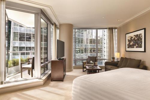 a hotel room with a bed and a living room at Hyatt Vancouver Downtown Alberni in Vancouver