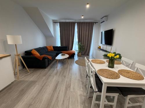 a living room with a couch and a table and chairs at Modern 2023 apartment in Kutno
