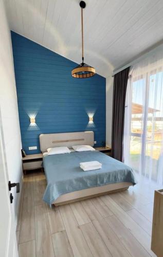 a bedroom with a blue wall and a bed at Kashka-Suu house in Verkhnyaya Alaarcha