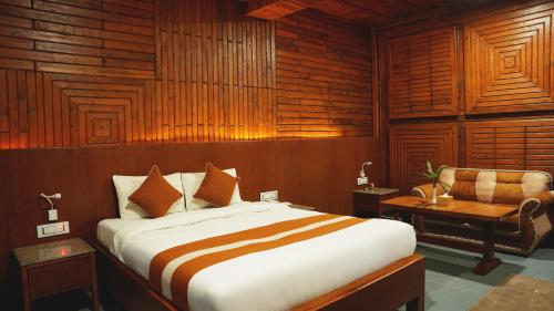 a bedroom with a bed and a desk and a chair at ila Comfort Harkapur in Maruwā Ghāt