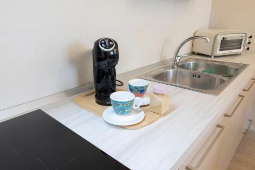 eine Küchentheke mit zwei Tassen und einer Kaffeemaschine in der Unterkunft Pasithea House in Lanciano