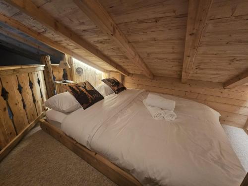 a large bed in a wooden room in a cabin at Chalet du Lac in Charmey