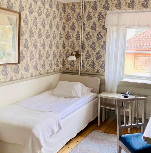 a small bedroom with a bed and a window at Sigtunastiftelsen Hotell & Konferens in Sigtuna