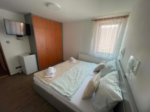 a bedroom with a bed with two towels on it at Hotel u Freuda Příbor in Nový Jičín