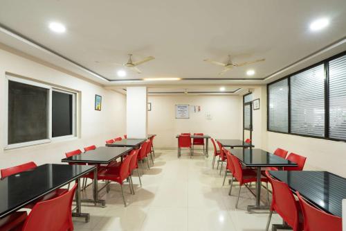 a classroom with black tables and red chairs at Olive Atnest PG in Hyderabad