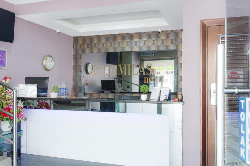 a restaurant with a counter and a clock on the wall at Dancenter Hotel Shah Alam in Shah Alam
