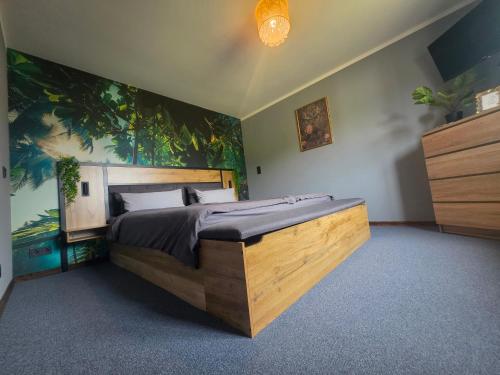 a bedroom with a large bed with a painting on the wall at Kleine Auszeit in Stolpe auf Usedom
