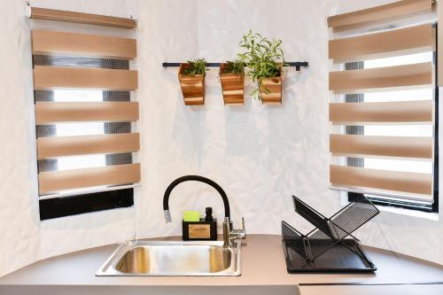a kitchen with a sink and two windows at Comfy Dots 2 in Larisa