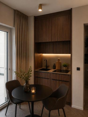 a kitchen with a table and chairs and a sink at NEW TOWN Boutique Apartments & Parking in Graz