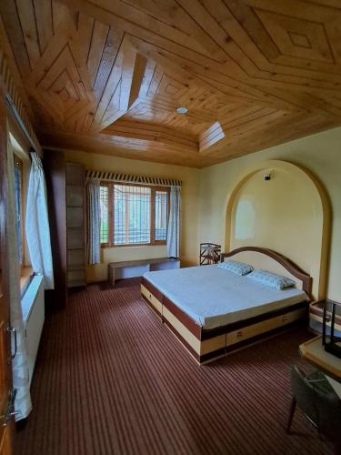 a bedroom with a large bed and a wooden ceiling at Shantiloka - Private 1BHK Homestay in Kulu