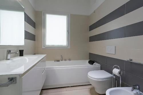 a bathroom with a tub and a toilet and a sink at Residence Armony in Misano Adriatico