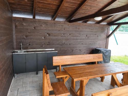 a patio with wooden benches and a sink at Oščadnica, Tadorka in Čadca