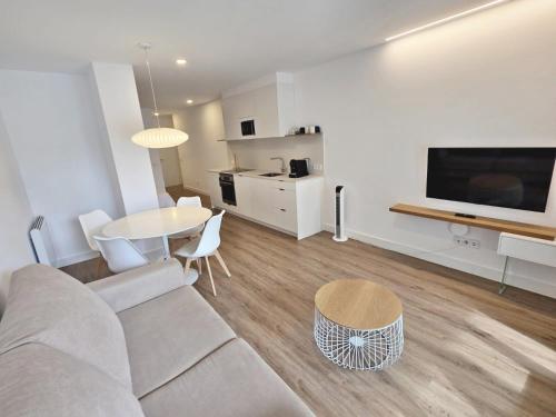 a living room with a couch and a table at BR Silgar Suites in Sanxenxo