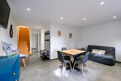 a living room with a table and a couch at Laurière - Wifi - Parking - Pet friendly in Port-Saint-Père
