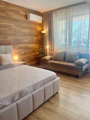 a bedroom with a large bed and a couch at Sunset Yavorov Pomorie in Pomorie