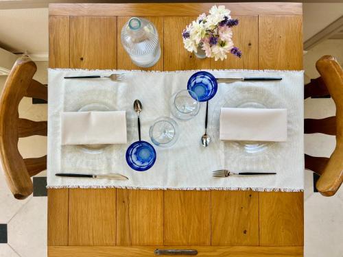 a table with blue plates and utensils on it at Maison Nolette - Chambres & Table d'hôtes in Noyelles-sur-Mer