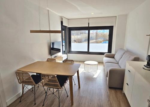 a living room with a table and chairs and a couch at BR Silgar Suites in Sanxenxo