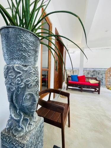 a large vase with a plant in a room at Kumudu Holiday Home in Hiriketiya