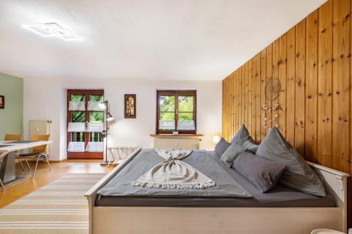 a bedroom with a bed with a wooden wall at Apartment Gardenview in Kinsau