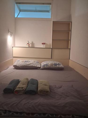 a bed with two pillows and towels on it at STRUNA in Ohrid