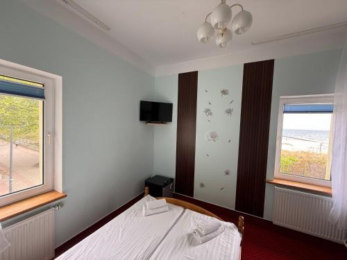 a bedroom with a bed and two windows at Zajazd Dajana in Ustka