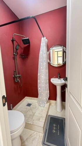 a red bathroom with a toilet and a sink at aROYAL in Cholpon-Ata
