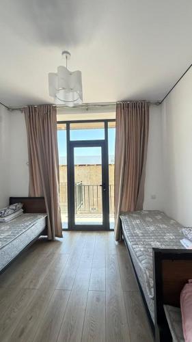 a room with two beds and a large window at aROYAL in Cholpon-Ata
