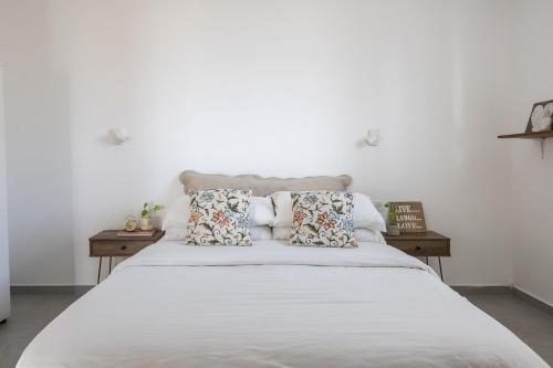 a bedroom with a large white bed with pillows at לגעת בלב in Yavneʼel