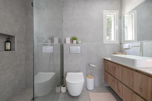 a bathroom with a toilet and a sink at לגעת בלב in Yavneʼel
