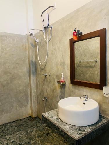 a bathroom with a sink and a shower at Greenbliss Hiriketiya in Dickwella