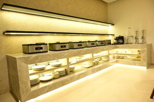 a kitchen with a counter with white dishes on it at Trevon Hotel Gujrat Centrale, Ranchi in Rānchī