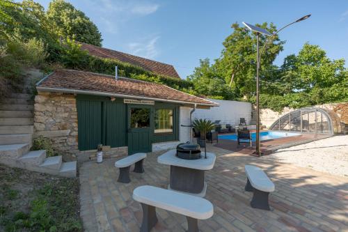 a patio with benches and a grill in front of a building at Döbrögi Wellness Vendégház in Nemesvita