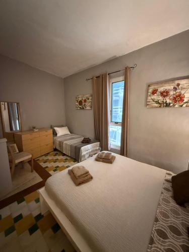 a bedroom with two beds and a window at Arantza House in Sliema