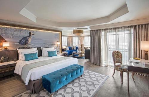 a bedroom with a large bed with a large painting on the wall at Labourdonnais Waterfront Hotel in Port Louis
