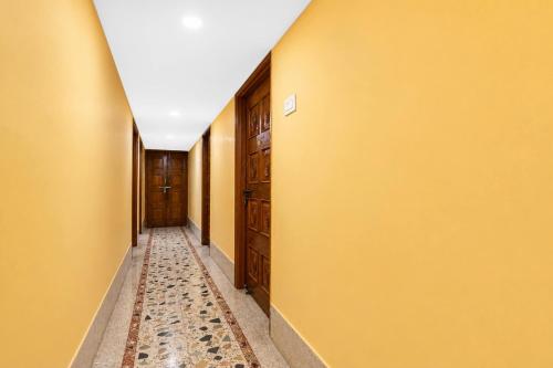 a hallway with yellow walls and a carpeted floor at SPOT ON Khedia Inn in Bokāro