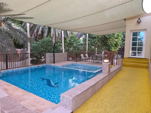 a swimming pool with a dolphin in the water at Hatta Orchard in Hatta