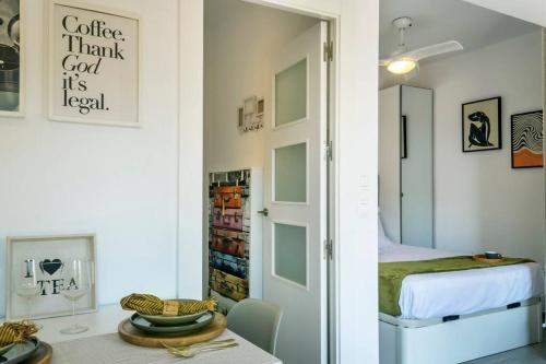 a room with a bed and a door with a table at Apartment Pink Vistalegre in Torrevieja
