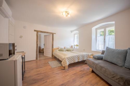 a living room with a bed and a couch at Döbrögi Wellness Vendégház in Nemesvita