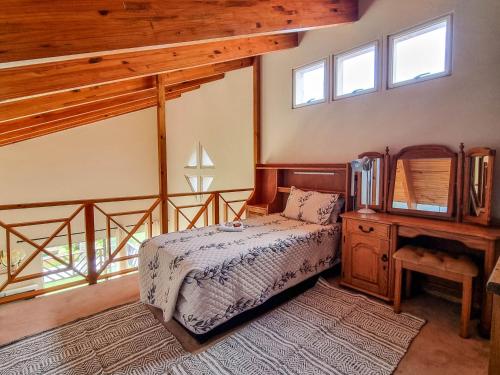 a bedroom with a bed and a dresser with a mirror at Bon A Vie Self-catering and b&b Gonubie Full Solar Power, no load shedding! in Gonubie