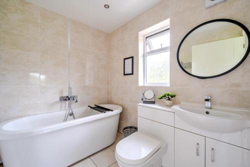 a bathroom with a tub and a toilet and a sink at Charcoal Lodge in Brigg