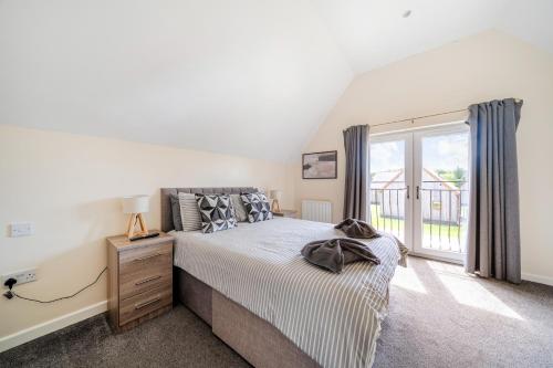 a bedroom with a bed and a large window at Charcoal Lodge in Brigg