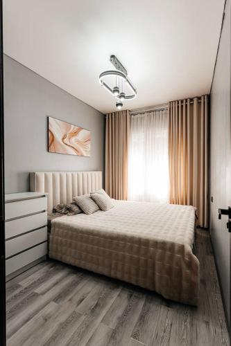 a bedroom with a large bed and a window at Modern Canadian Style Unit in Tashkent
