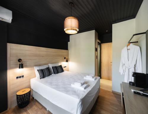 a bedroom with a large white bed with a black ceiling at Salty Dog Suites in Vasiliki