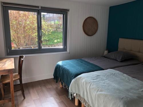 a bedroom with two beds and a desk and a window at Bienvenue à Evian in Neuvecelle