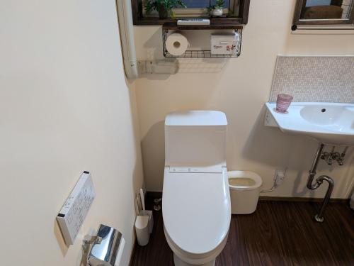 a small bathroom with a toilet and a sink at Hatoya in Mitoyo