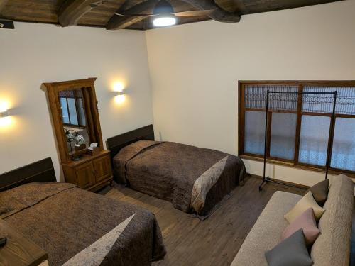 a hotel room with two beds and a couch at Hatoya in Mitoyo
