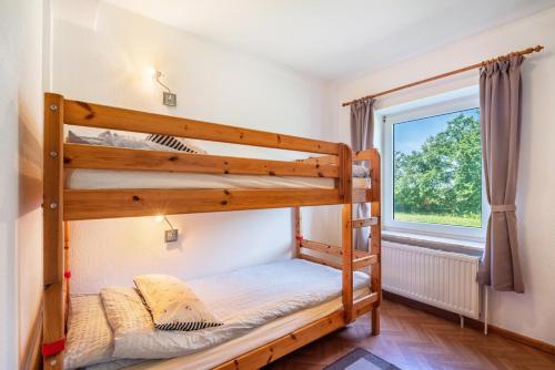 a bedroom with two bunk beds and a window at Fewo Hanna Tedsen in Pellworm