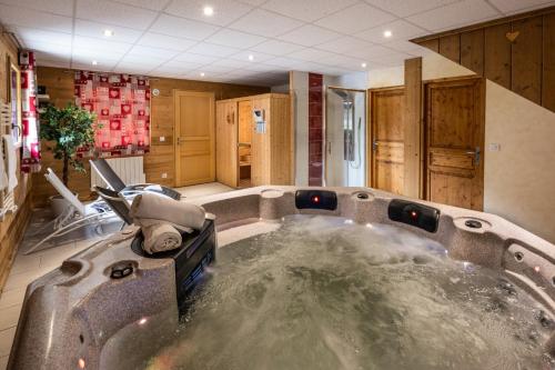 a jacuzzi tub in the middle of a room at Chalet Snow Mountain in Le Bettaix