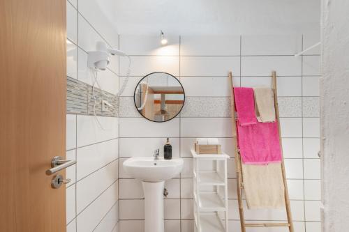 a white bathroom with a sink and a mirror at Monte Corte Enchária in São Teotónio