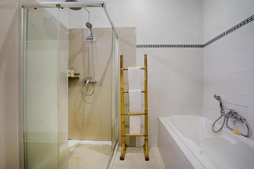 a bathroom with a shower and a tub and a sink at Kubu Kapas Bali in Ubud